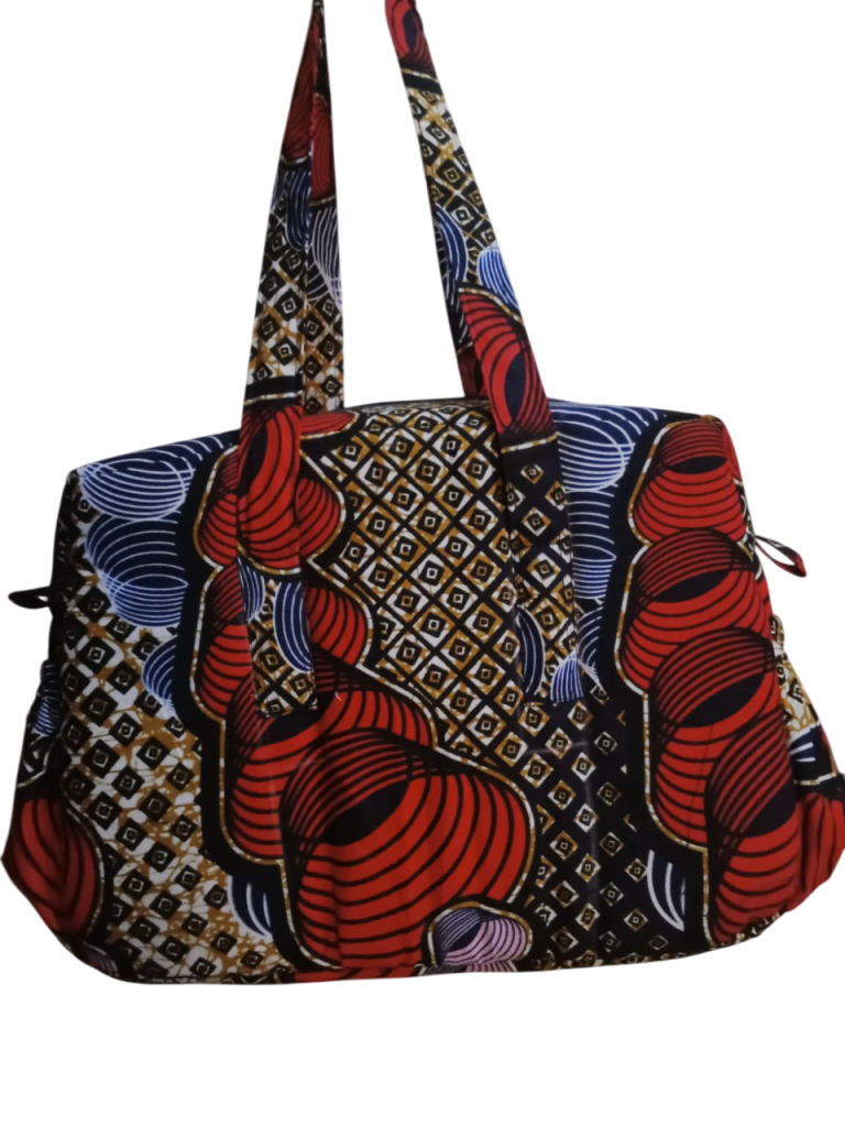 Upgrade your daily carry with our African Print Zip-Top Tote. Perfectly balancing functional design with high-impact aesthetics, this bag takes you from morning meetings to weekend brunch without missing a beat. Product Features: Secure Closure: Durable top zipper to keep your essentials safe. Spacious Design: Roomy interior for your laptop, makeup bag, and daily essentials. Sturdy Straps: Reinforced shoulder straps for comfortable all-day wear. Premium Fabric: 100% authentic African Wax Print (Ankara) with a structured lining.